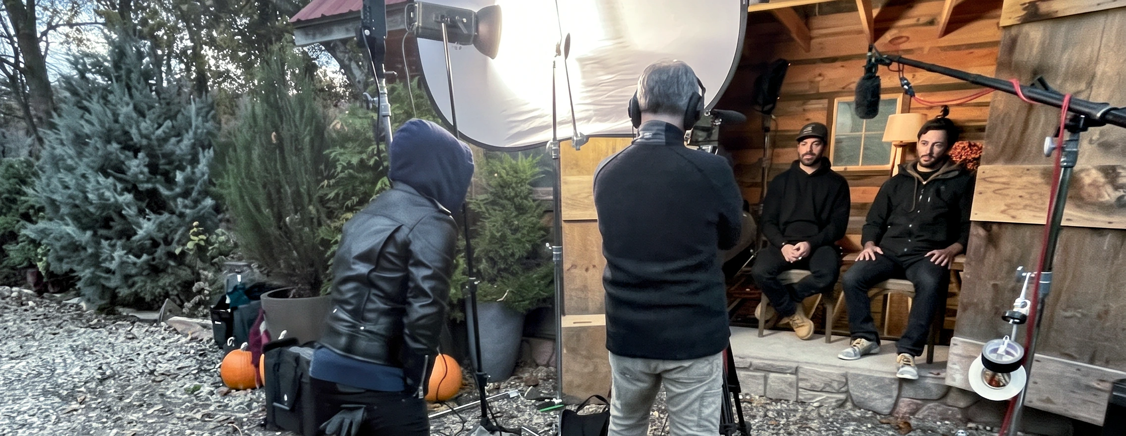 Crew setting up a client interview on a cabin porch at golden hour